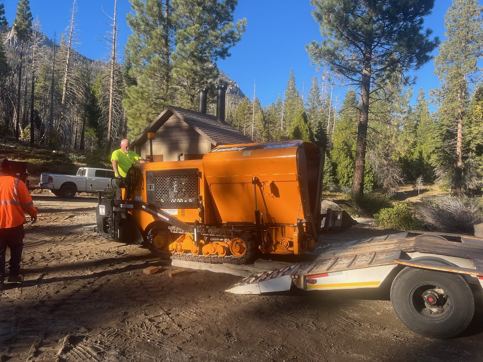 Asphalt paver being unloaded at the Bush Loop trailhead in Sequoia National Forest